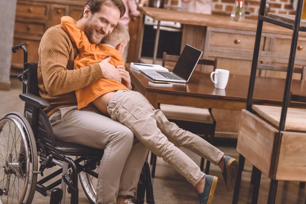 man in wheelchair hugging son