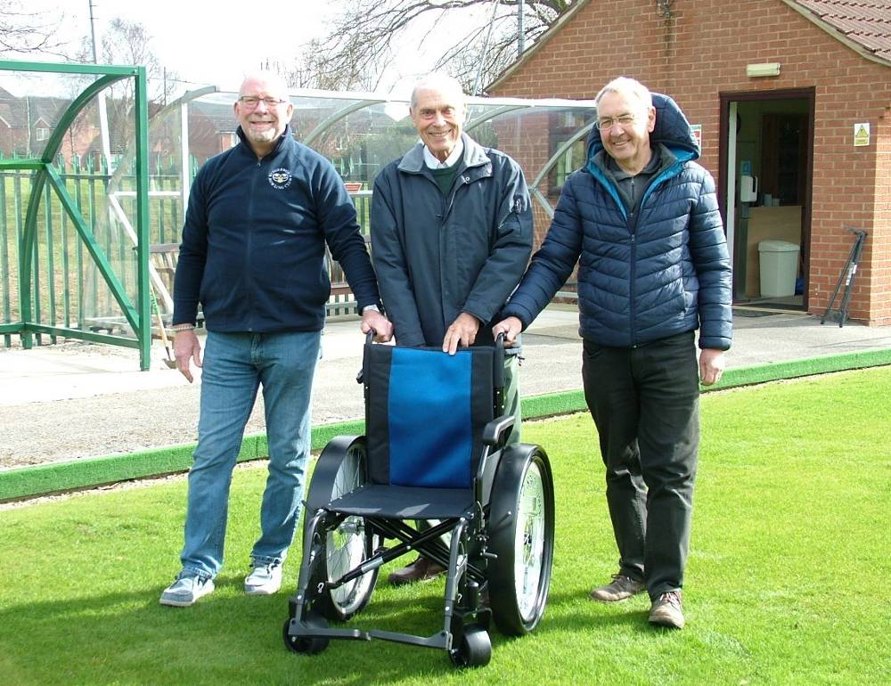 3 members stood behind wheelchair