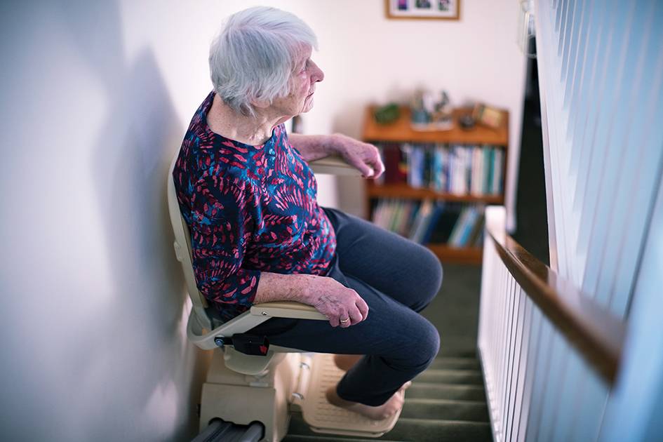 A senior woman on a stairlift